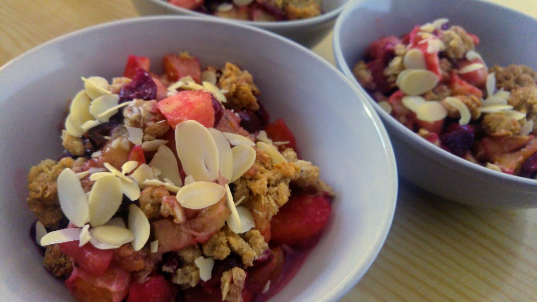 Fruit crumble served in bowls, garnished with almond flakes