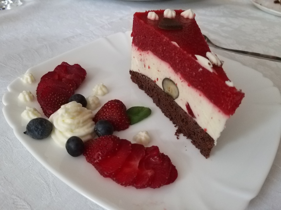 A slice of white and dark chocolate strawberry layer cake on a plate
