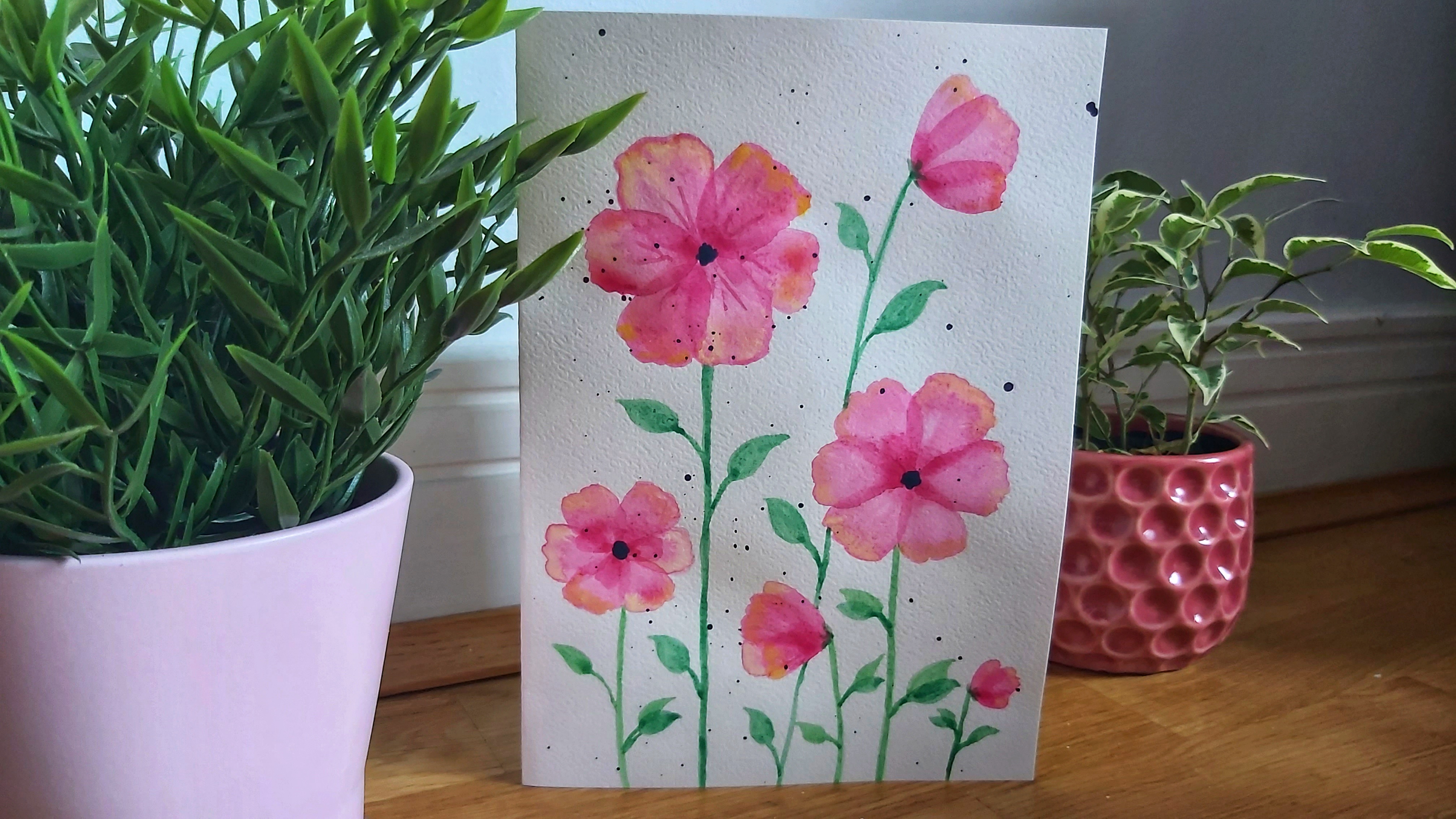 Completed pink watercolour poppies card between two flower pots